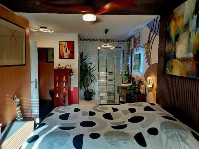 Chambre rénovée ouvrant sur une salle d'eau vitrée