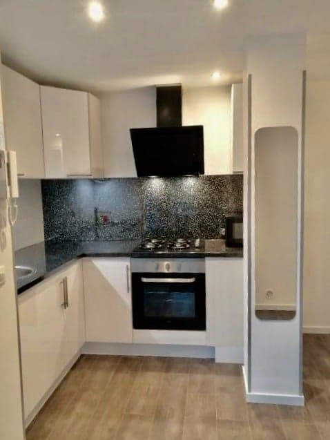 Cuisine blanche avec crédence en mosaïque noire et hotte design