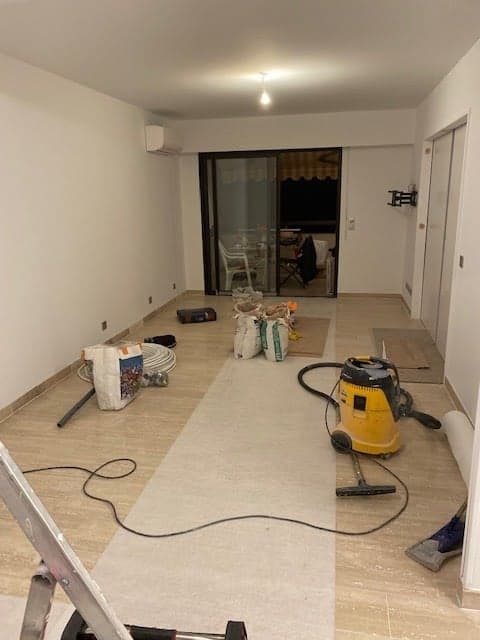 Séjour en travaux : sols protégés, murs préparés avant peinture
