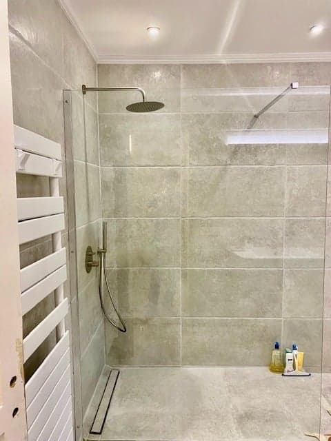 Douche à l'italienne avec carrelage gris grand format et sèche-serviettes